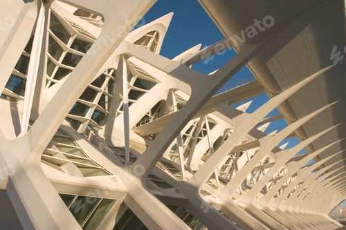 Preview: Modern architecture showcasing an intricate white skeletal structure against a clear blue sky.