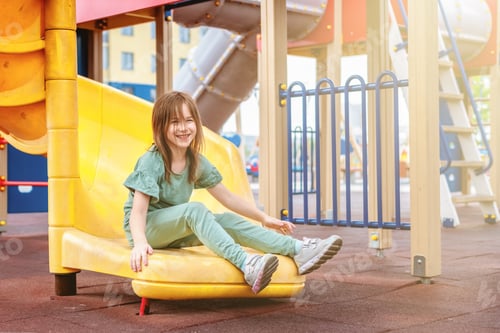 Preview: a girl is rolling down a slide in the courtyard