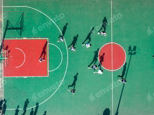 Preview: Aerial view of a group of young people playing basketball on a basketball court.
