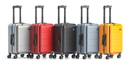 Preview: Row of suitcases of different colors isolated on white background.