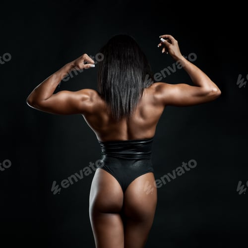 Preview: Muscular Strong Woman Posing Against Black Background