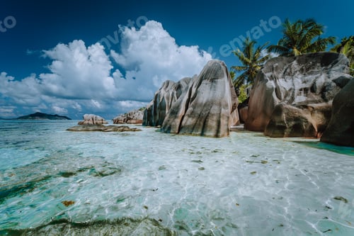 Preview: Granite boulders in shallow ocean water and white cloudscape on amazing Anse Source D'Argent