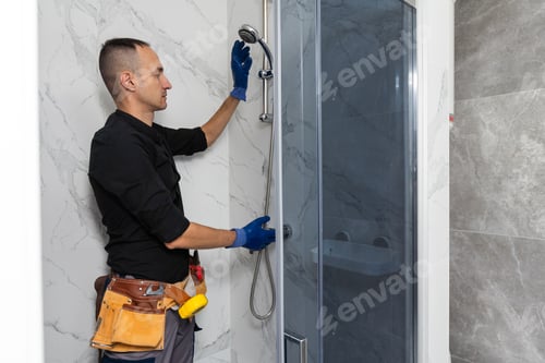 Preview: Professional handyman working in shower booth indoors