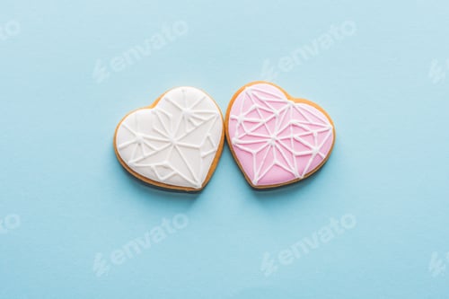 Preview: top view of two glazed heart shaped cookies isolated on blue, st valentines day holiday concept