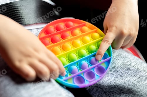 Preview: kids anti stress sensory pop it fidget push toys in kid's hands. child playing with a toy in a car