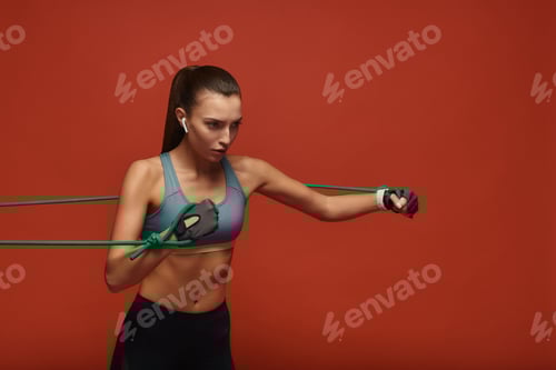 Preview: Woman Exercising with Resistance Band on Red Background