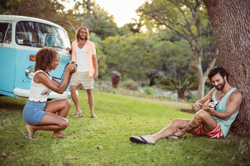 Preview: Woman taking a picture of man playing a guitar