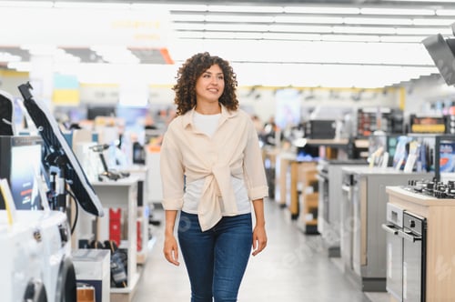 Preview: Woman walking through electronics store choosing home appliances