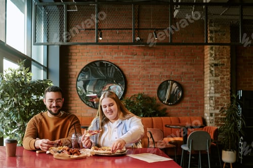 Preview: Young Man and Woman Enjoying Lunch Together in Modern Cafe Setting