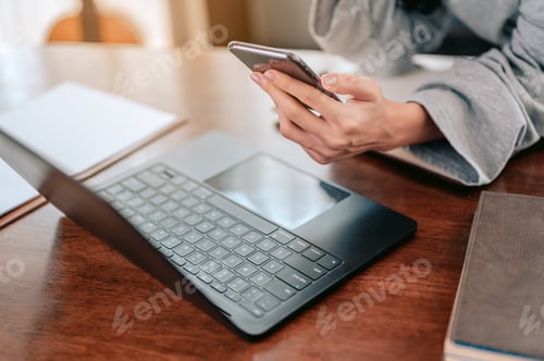 Preview: Asian woman working from home overtime. Close up hands used smartphone.Work from home