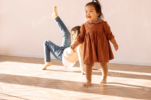 Preview: Little girls of different races in casual clothes play in living room of house on sunny day