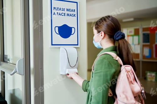 Preview: Girl wearing face mask disinfect their hands