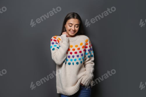 Preview: Beautiful young woman in warm sweater on dark background