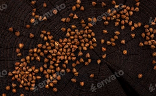 Preview: Heap of buckwheat grain on black wooden background. Top view