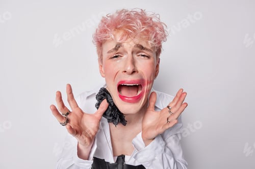 Preview: Upset crying pink haired gay spreads palms looks desperate at camera has doleful sad expression