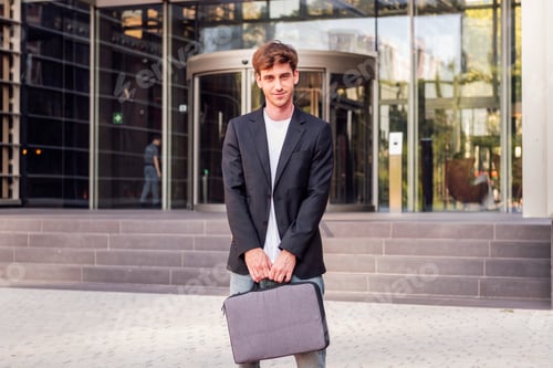 Preview: man holding briefcase in front of office building