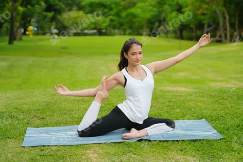 Preview: Woman practicing yoga balance at park