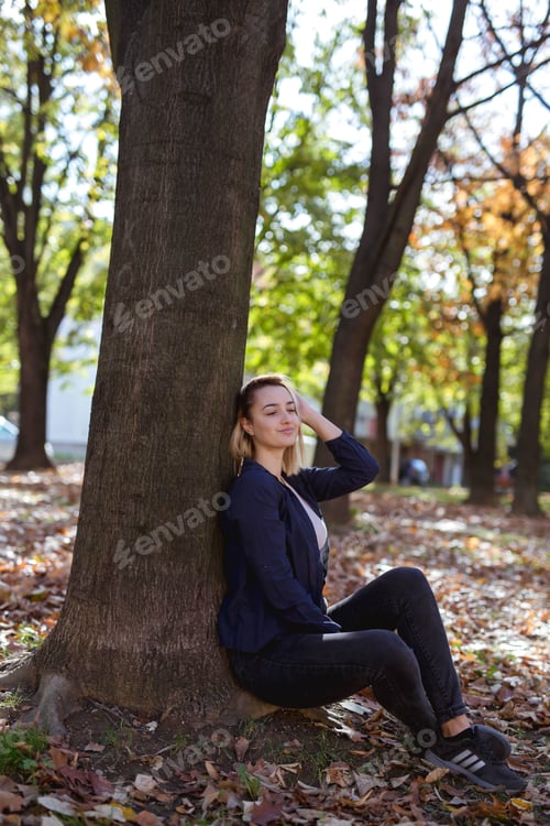 Preview: Vertical shot of a beautiful Caucasian female posing in a park