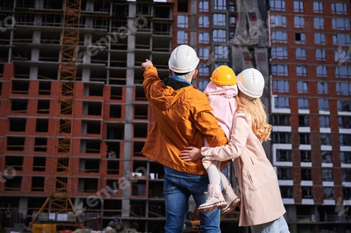 Preview: Family with child looking at apartment building under construction.
