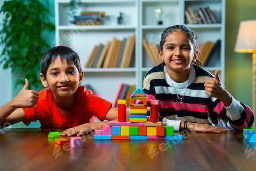 Preview: Indian Kids Building Structures with Colorful Wooden Blocks and Playing Joyfully at Home