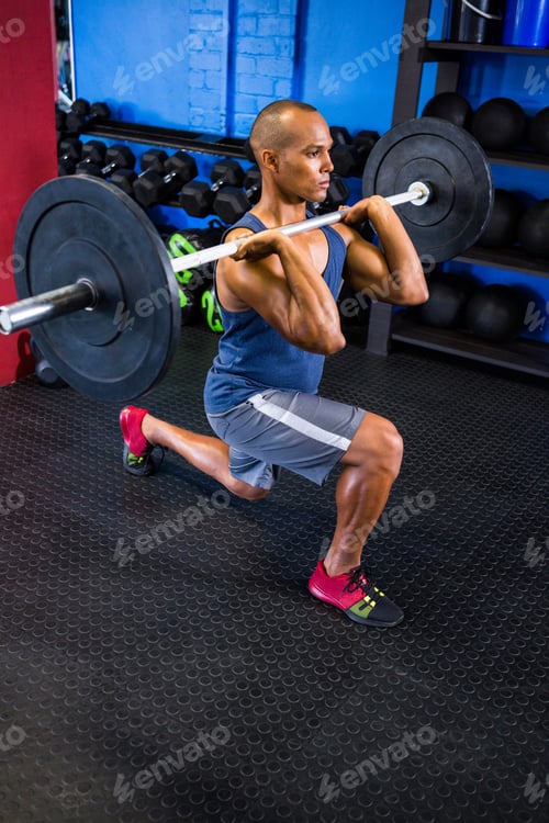 Preview: High Angle Of Determined Man Lifting Barbell In Fitness Studio