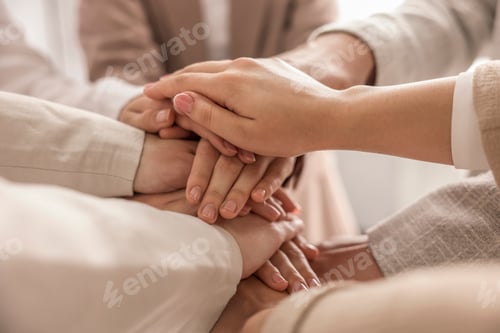Preview: Group of people holding hands together indoors, closeup. Unity concept