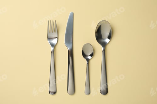 Preview: Cutlery on beige background, top view and space for text