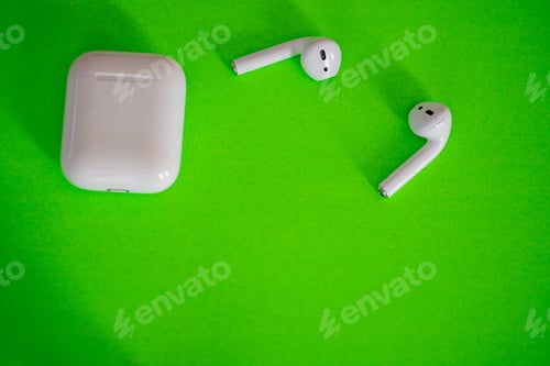 Preview: Wireless earbuds shot from directly above against green background