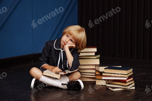Preview: A schoolgirl is sitting surrounded by textbooks