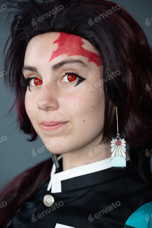 Preview: Caucasian female cosplayer in a blue costume with face paint and red contact lenses