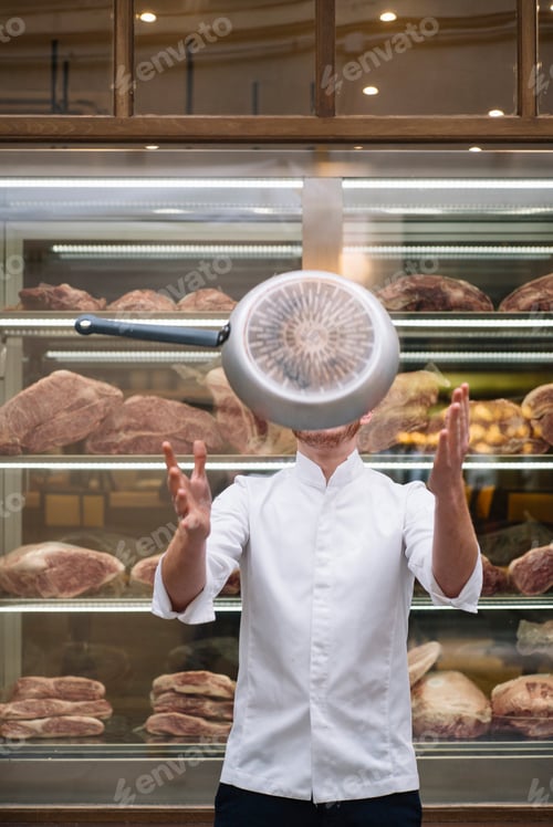 Preview: Chef in jacket with frying pan in air