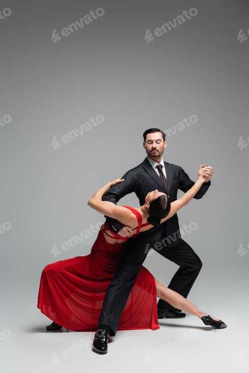 Preview: Dancer in suit performing tango with elegant partner on grey background