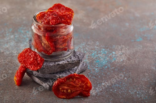 Preview: Fermented vegetarian canned food concept. Pickled dried tomatoes in a glass jar.