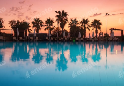 Preview: Beautiful reflection in swimming pool at colorful sunset