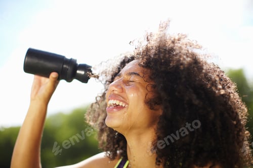 Preview: Young woman pouring water onto face in park