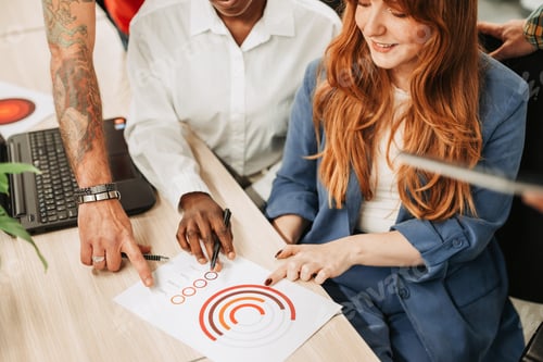 Preview: High angle shot of a diverse business team hands pointing on a charts