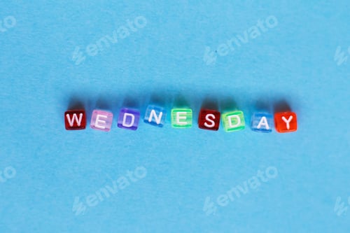 Preview: inscription wednesday made by multicolor plastic cubes on a blue background.