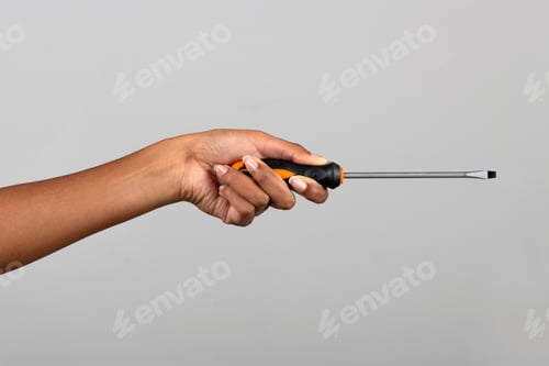 Preview: Black female hand showing screwdriver