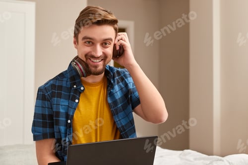 Preview: Smiling Man Using Laptop Indoors During the Daytime