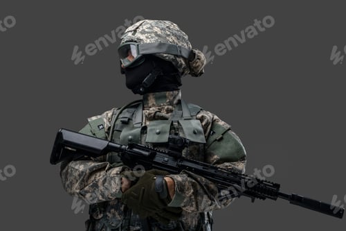 Preview: Brave soldier with rifle looking away against gray background
