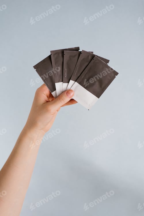 Preview: Disposable Bags with Cosmetics in a Woman's Hand on Blue Background
