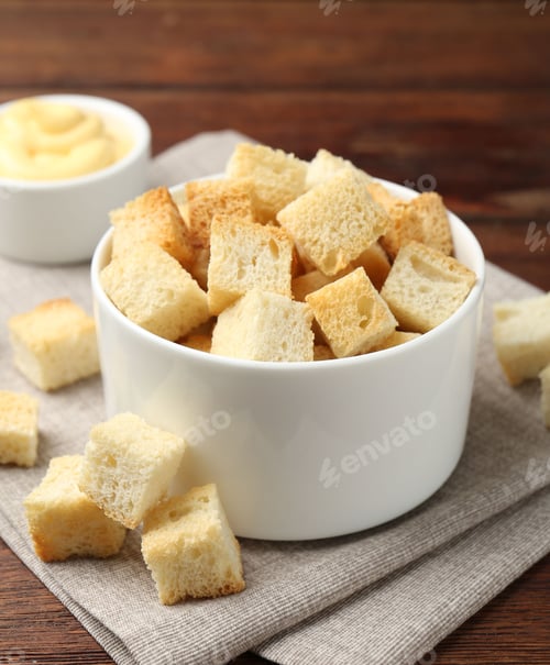 Preview: Delicious crispy croutons with sauce on wooden table, closeup