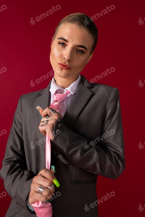 Preview: Stylish young woman in a chic suit expressing confidence with a striking pose