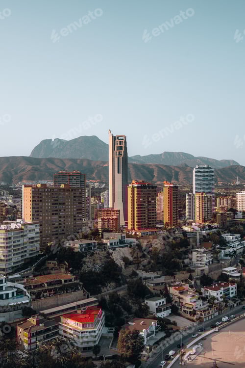 Preview: Cityscape View Featuring Modern Buildings and Mountain Backdrop