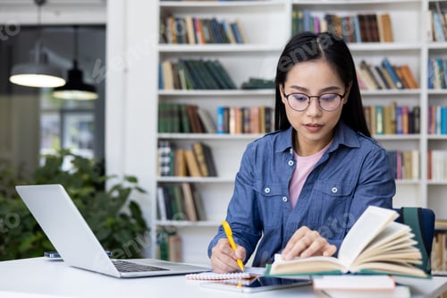Preview: An attentive student researches and studies surrounded by books in a library setting.
