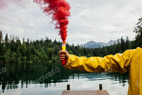 Preview: Man standing on the lake walkway with smoke bomb