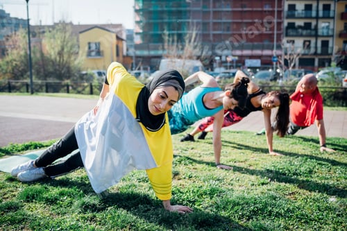 Preview: Calisthenics class at outdoor gym, women and man practicing sideways yoga position