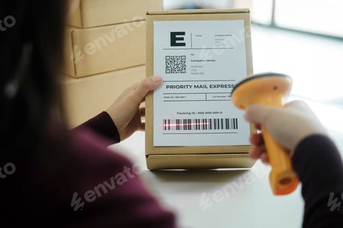 Preview: Female online business owner scan shipping label on parcel.