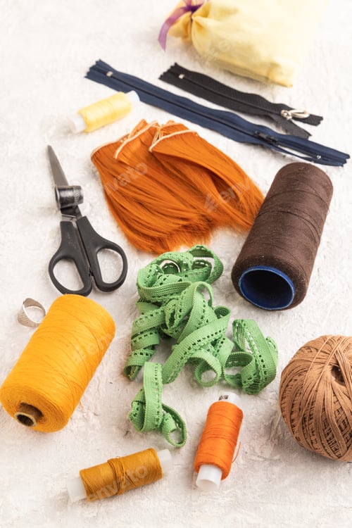 Preview: Sewing accessories: scissors, thread, thimbles, braid on gray concrete. Side view