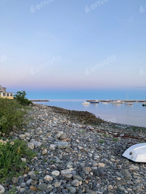 Preview: Rocky shoreline with multiple boats in the background. Rye Beach Harbor, USA.
